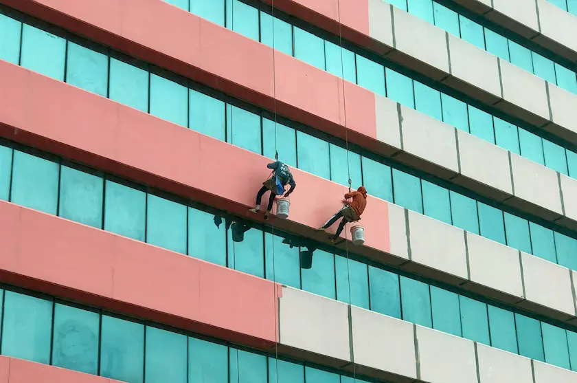 Industrial climber painting a building at height